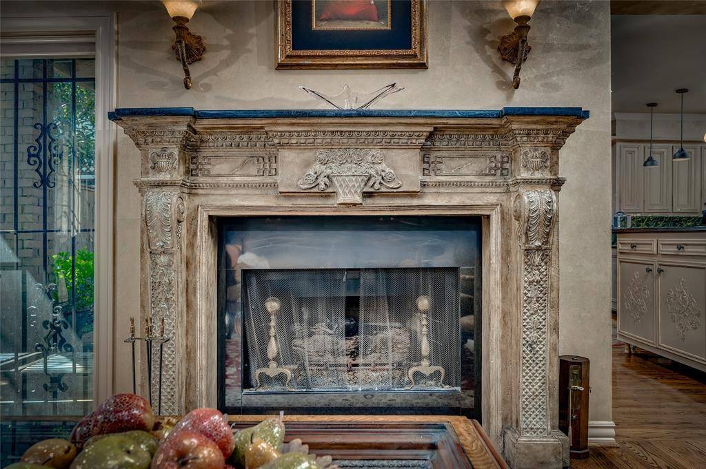 The fireplace is beautifully illuminated by bronze sconces & carefully positioned art lighting.