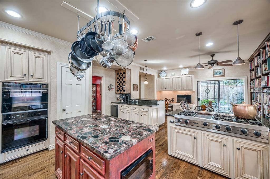 The well-appointed kitchen features a Viking cooktop with a griddle, Miele double ovens, granite countertops, and plentiful natural lighting.