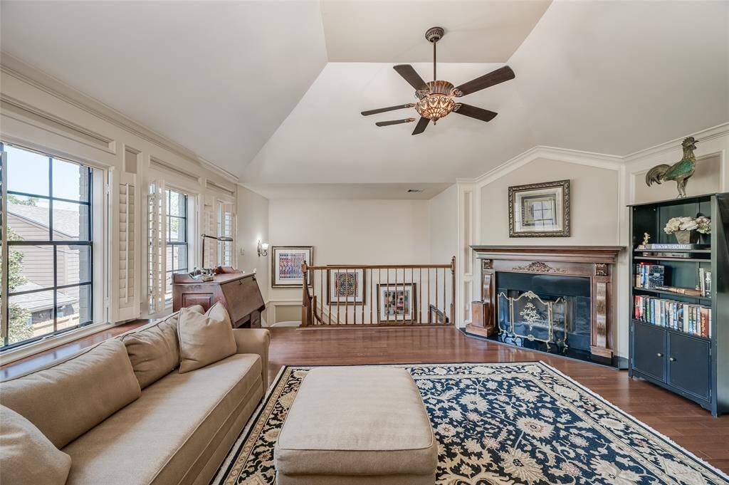 The game room features a wall of windows with plantation shutters providing exceptional natural light, plus custom wall millwork throughout the room.