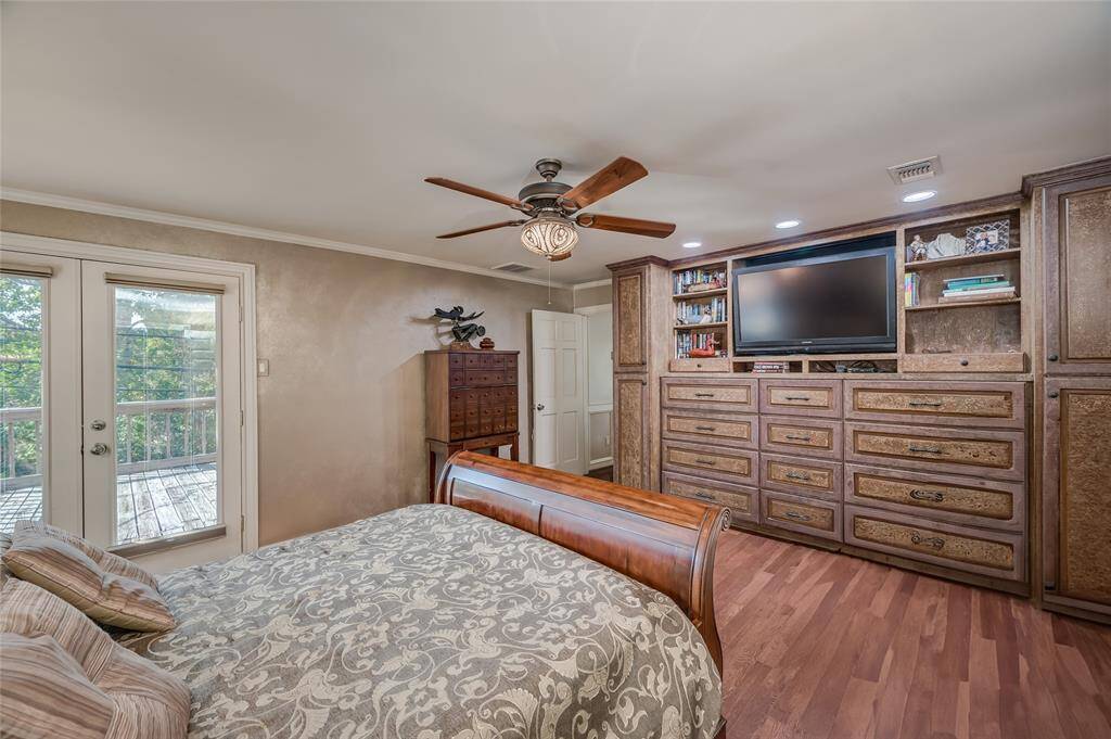 Custom faux-painted built-in cabinetry in the primary bedroom provides tons of practical storage.