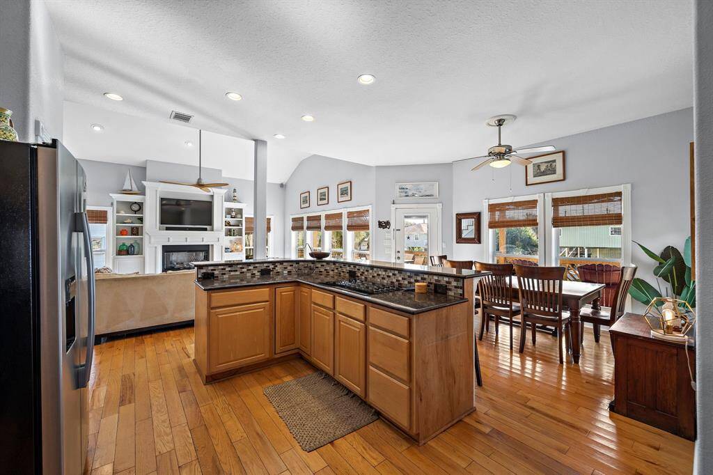 The kitchen opens up to the dining and living area with a raised bar and plenty of counter seating. Recessed lighting and an open-concept layout make this the heart of the home, ideal for hosting family and friends.