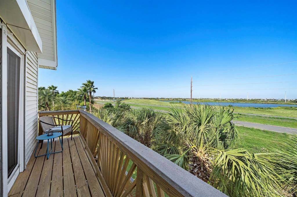 Step onto the private balcony off the upstairs guest bedroom and enjoy peaceful lake views surrounded by swaying palms—perfect for a quiet moment or evening breeze.