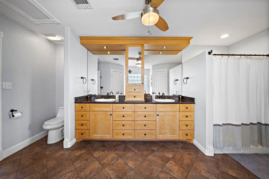 This angle shows the full layout of the primary bathroom, with a soaking tub, walk-in shower behind a privacy wall, and a generous double-sink vanity.