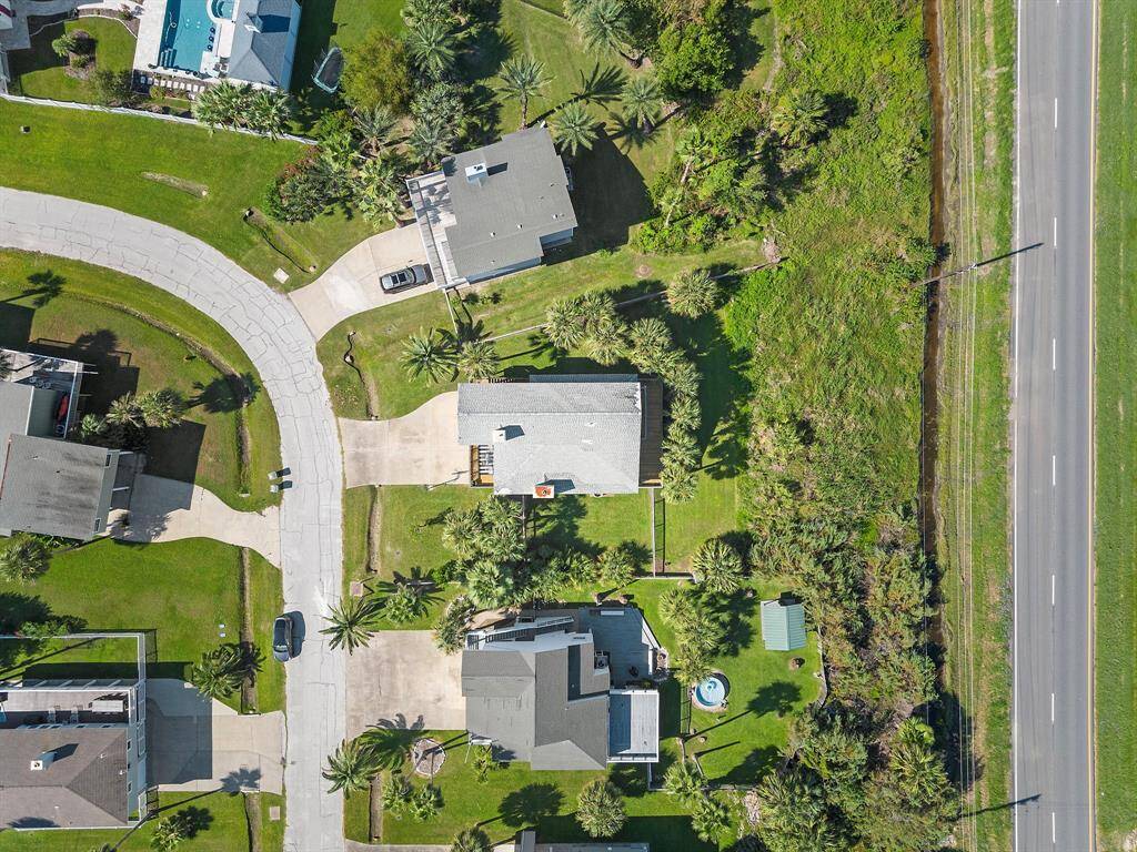 Aerial view highlighting the expansive lot and well-maintained yard, with no immediate back neighbors and convenient access to the main road—offering both space and ease of access.