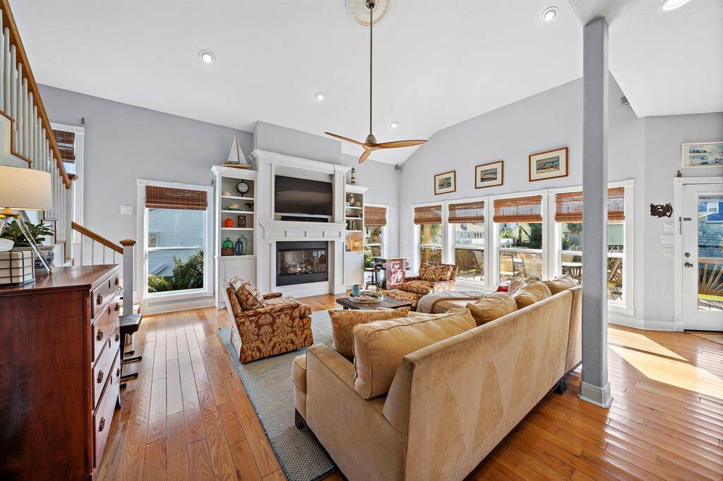 An entire wall of windows fills the space with sunlight and provides peaceful views of the surrounding palms and neighborhood. The open feel is balanced with warm tones and soft textiles, creating a relaxed yet elegant atmosphere.
