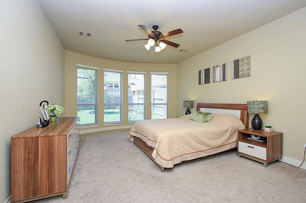 Primary bedroom with ceiling fan and space to put a treadmill.