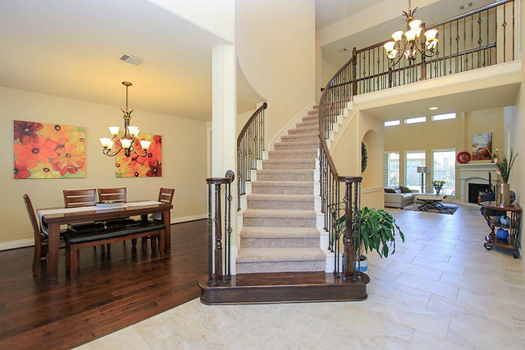 Spacious entry with high ceiling and sweeping stairs. Feel so open!