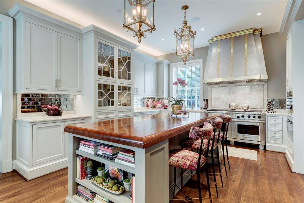 No expense spared designing this new kitchen with stunning custom designed brass vent hood, quartz countertops, mirrored glass tiles and cabinet detail.  Island with rich wood top and multiple built-ins serves as nice breakfast bar for informal dining.