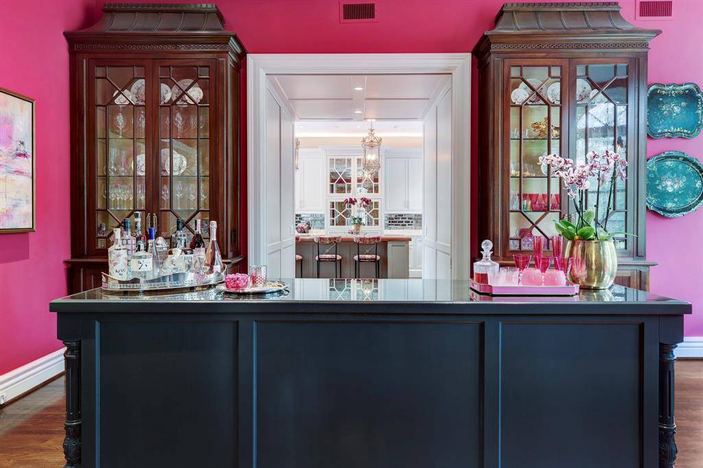 The China Room which is a pass through room between the kitchen and dining room, features four gorgeous custom built-in china cabinets with a central built-in island that functions as a buffet and open bar area.  The island has multiple builtins, with built-in Sub Zero undercounted beverage refrigerator and wine storage unit, along with Hoshizaki ice maker.