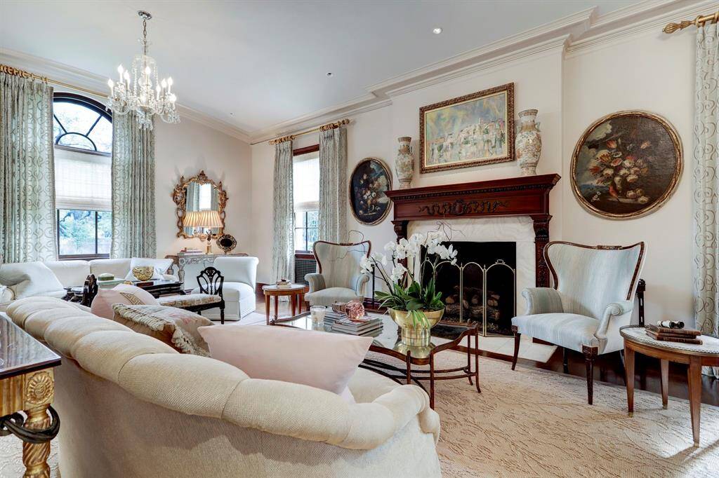 The generous Formal Living room with carved wood mantel and marble surround, allows for multiple seating arrangements. Sellers worked with designer Sherry Hayslip (Dallas), to achieve a timeless feel throughout the home.