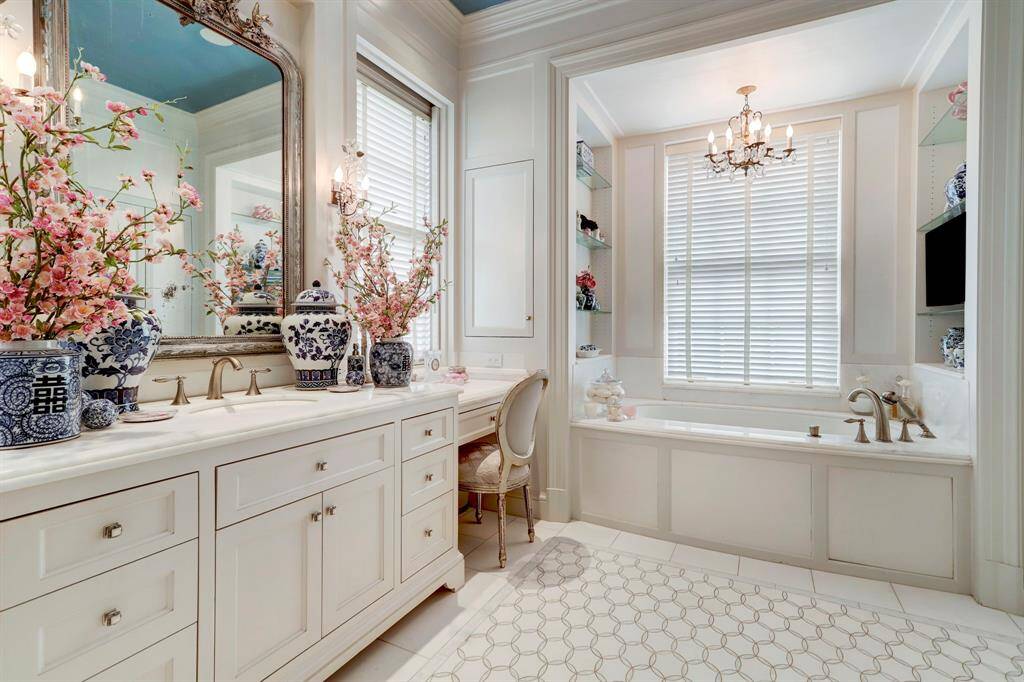 Primary Bath #1-Her primary bath with marble counters and and Ann Sacks mother of pearl tile floors, vanity area and soaking tub. Notice the exquisite detail on the mother of pearl cabinet pulls - like jewelry!