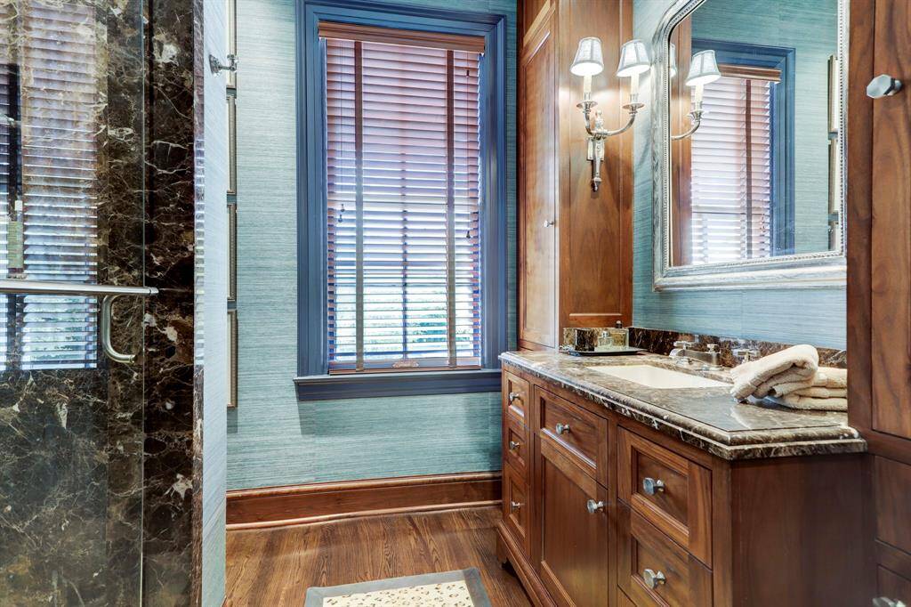 Primary Bath #2 -Handsome bath with marble shower and counter tops, wood blinds and hardwood floors.