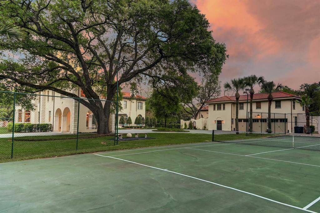 Tennis or Pickleball...Rear view of home taken from the tennis court.  To the right of the majestic oak is the 3 car Carriage House with a 2 bedroom apartment above with full kitchen (1,200+ sq.ft) and 1/1 suite on lower level.  Behind the Carriage House is an intimate courtyard and an “Artist Cottage” (330+ sq.ft.)
