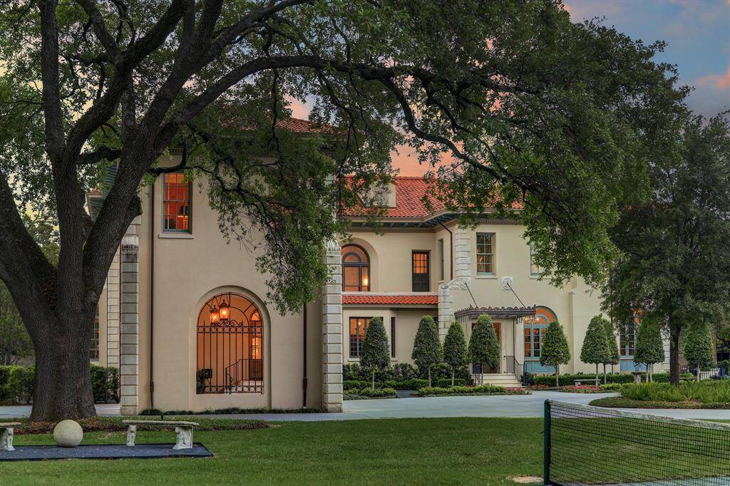 Picturesque view of the newly designed addition with 2 car Sallie Port.  Note the attractive custom iron work that matches the original design of the home.  The limestone detailing and red tile roof were meticulously matched to existing architectural elements to create this seamless addition.