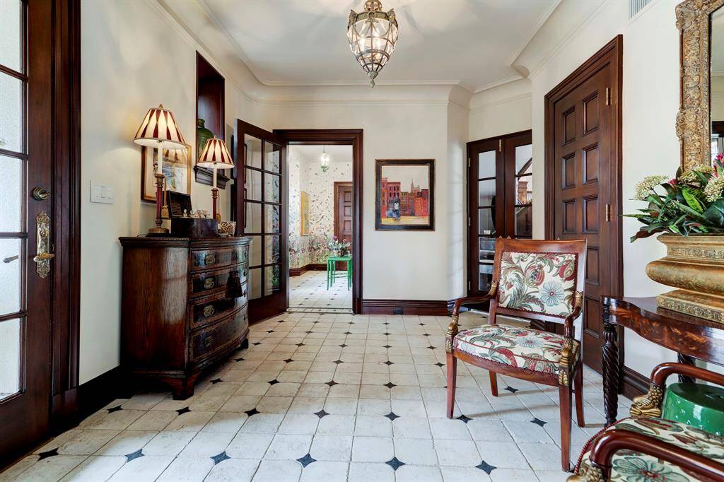 Rear Entry Hall is a secondary reception area and connects to main Reception Hall through glass paned doors. This light-filled entry hall also opens to the Sun Parlor and Conservatory.
