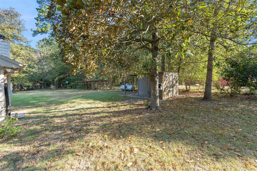 Here is a view of the back yard with the well house that has some space and protection from the weather for the well.