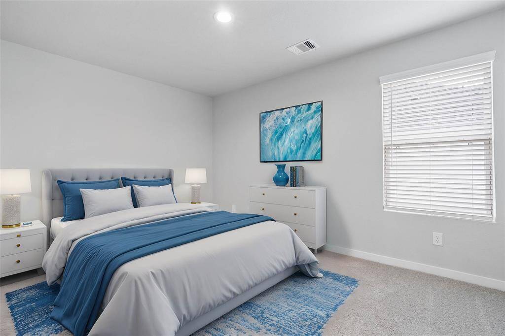 This secondary bedroom features custom paint, plush carpet, and a large window with privacy blinds!