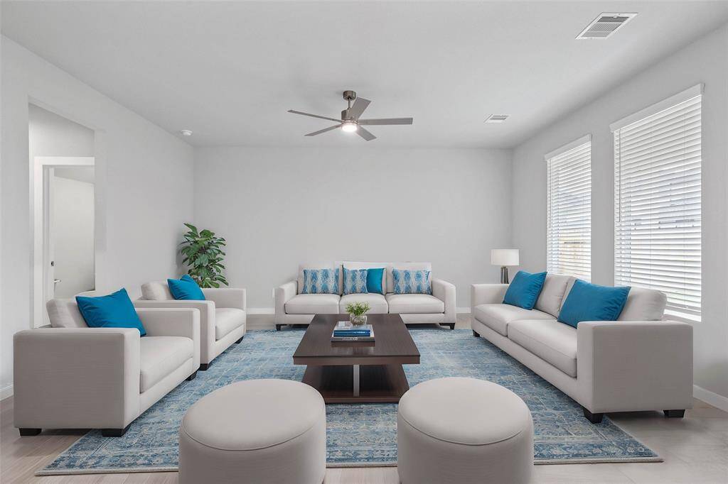 This light and bright spacious family room is the perfect layout for entertaining or just relaxing! Whether it's simply a night in or entertaining family and friends, this home has ample open space for everyone to enjoy! Featuring large windows, ceiling fan with blinds, and wonderful access to your gorgeous kitchen!
