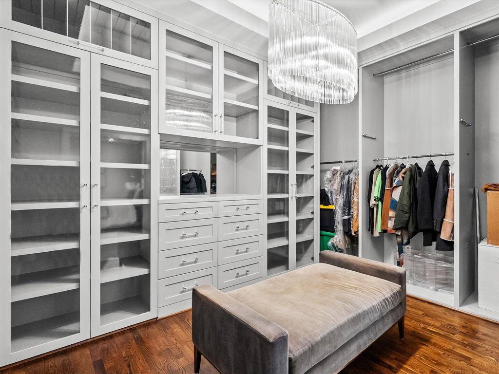 Experience luxury with one of the three expansive walk-in closets in the primary suite, featuring elegant built-ins and sophisticated finishes.