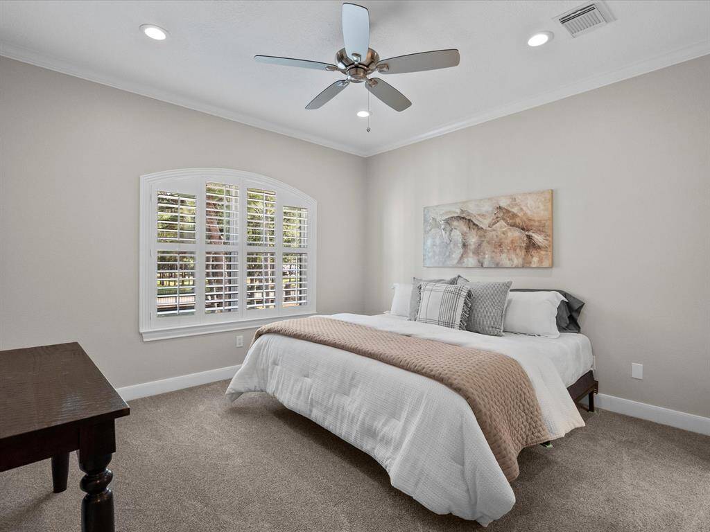 Upper-level primary suite with elegant shutters and abundant natural light.