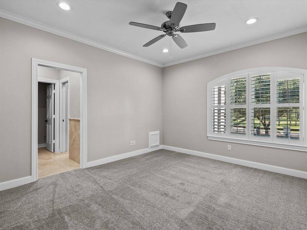 Inviting upper-level bedroom featuring plush carpeting, ample natural light, and a tranquil view.