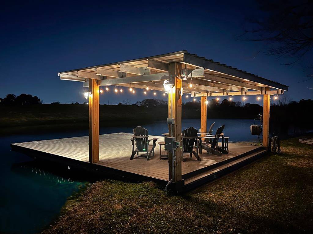 Enchanting evening ambiance on the illuminated deck overlooking the serene pond.