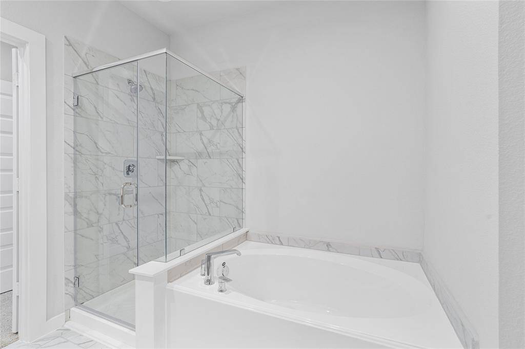 Additional view of the primary bath features a walk-in shower with tile surround and a separate garden tub perfect for soaking after a long day.