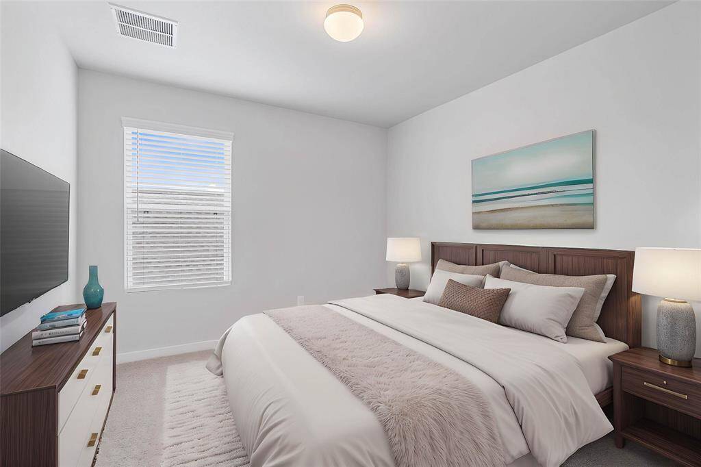 Secondary bedroom features plush carpet, custom paint, lighting, ample closet space, large windows with privacy blinds, and access to a private bath.