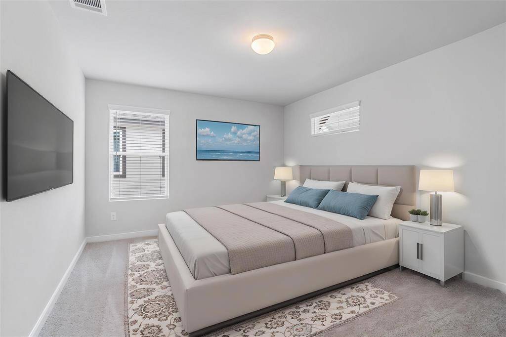 Secondary bedroom features plush carpet, custom paint, lighting, ample closet space, and large windows with privacy blinds!