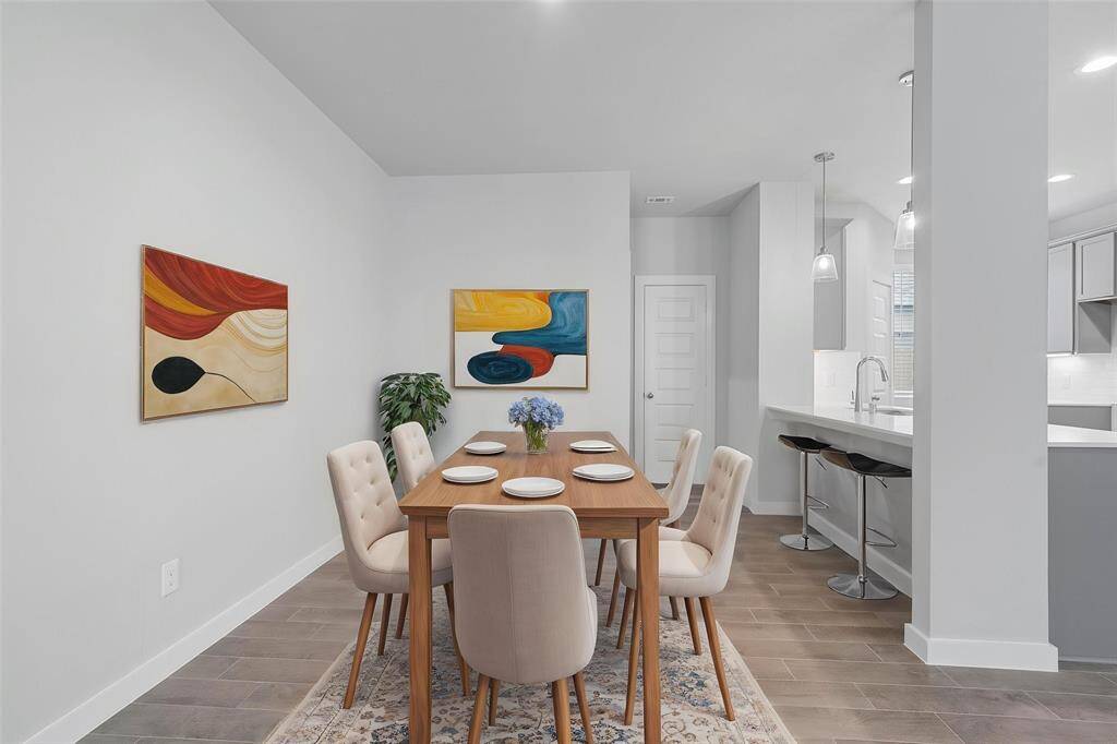 Make memories gathered around the table with your family and friends! This dining room features high ceilings, custom paint, wood look tile flooring, and recessed lighting!