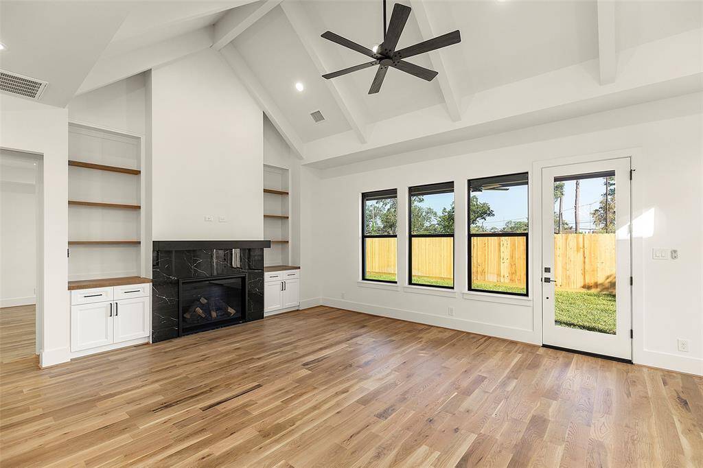 Proceeding further down foyer you enter the wonderful great room with its fireplace, multiple windows. It looks to the Lanai and fenced backyard, notice the custom wood work on either side of the fireplace