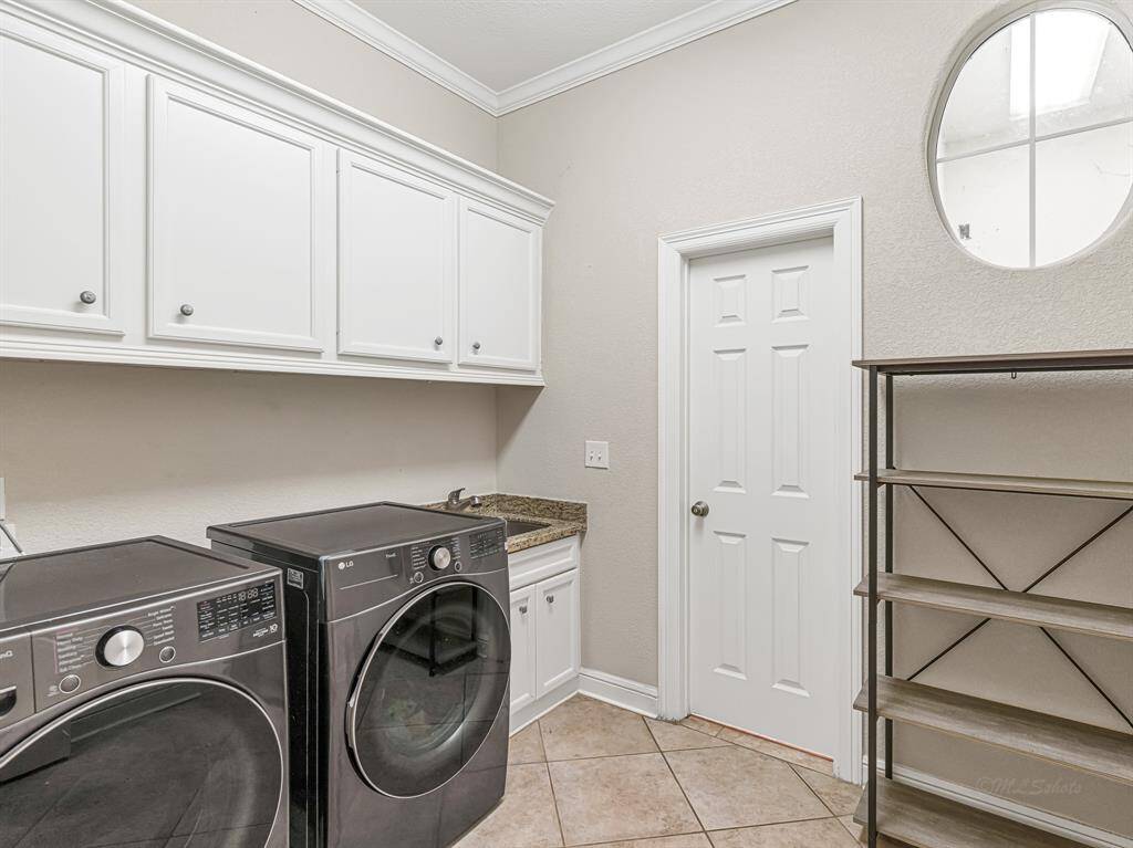 Laundry room with sink area and storage. Even has room for an additional fridge or freezer
