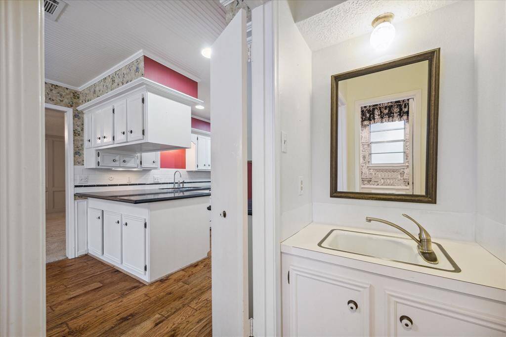Strategically positioned for ease of access, the guest powder room adjoins the kitchen and garage.