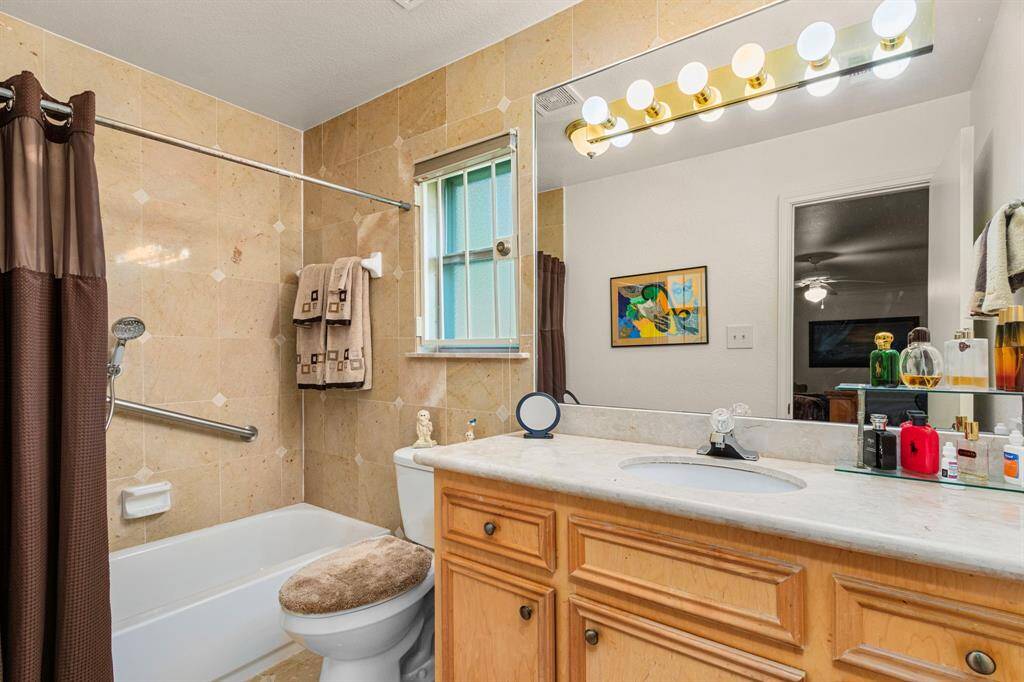 Primary bathroom with full tile wall and upgraded cabinet and vanity.