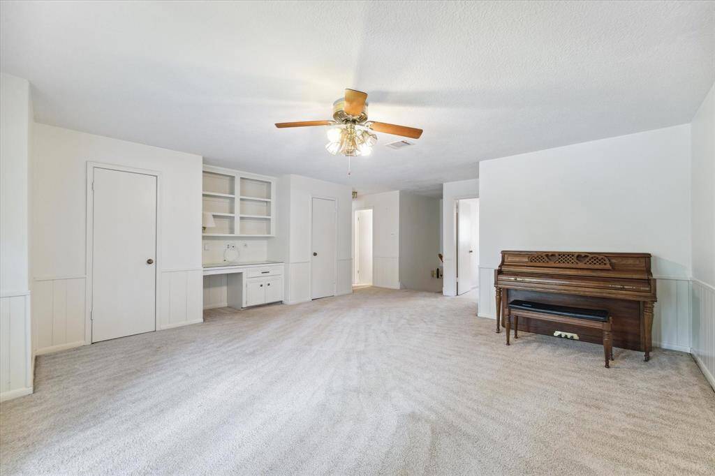 Spacious game room featuring ample storage with twin closets and a built-in work desk, for both play and productivity.
