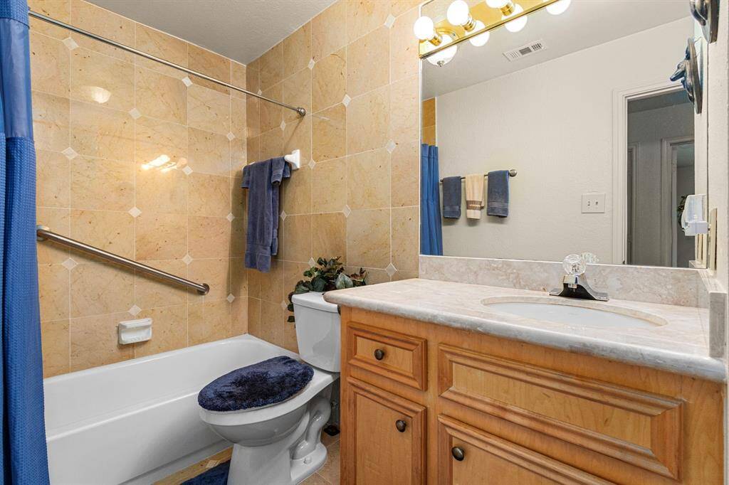Hall Bathroom also has a full tile wall and custom cabinetry.