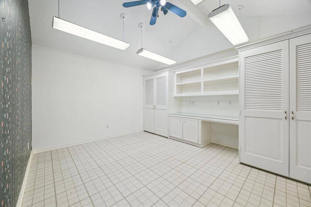 Streamlined home office featuring ample built-in storage and a spacious desk area, perfect for productivity.