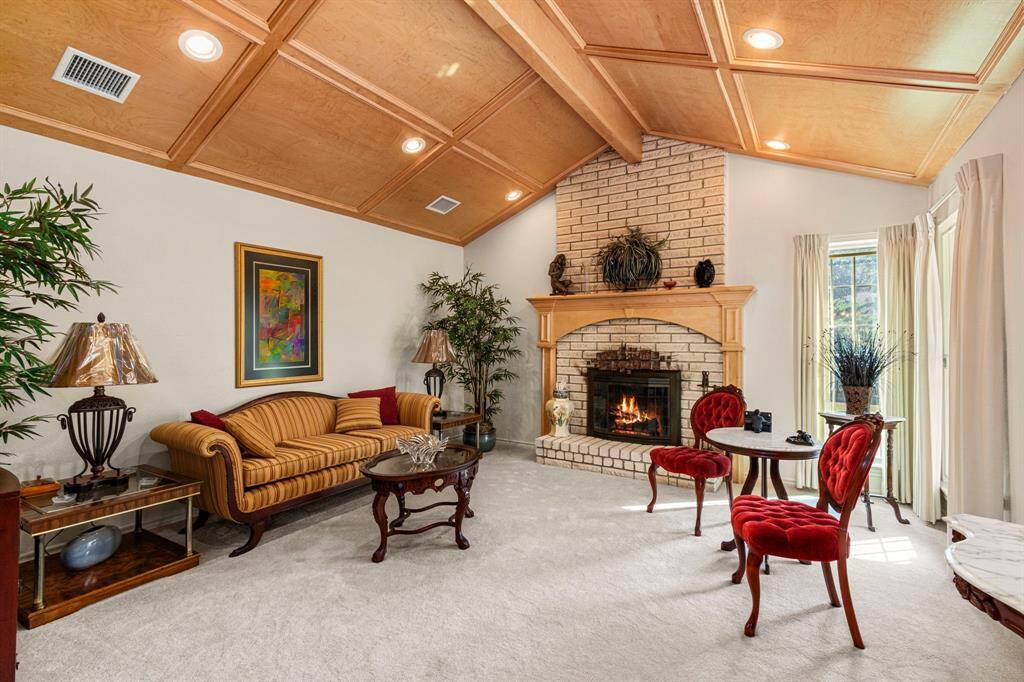 Elegant formal living room with vaulted ceiling complete with block paneling and recessed lights.