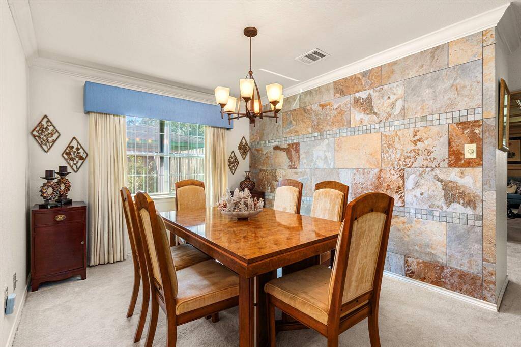 Formal dining room with accent wall and crown moulding.