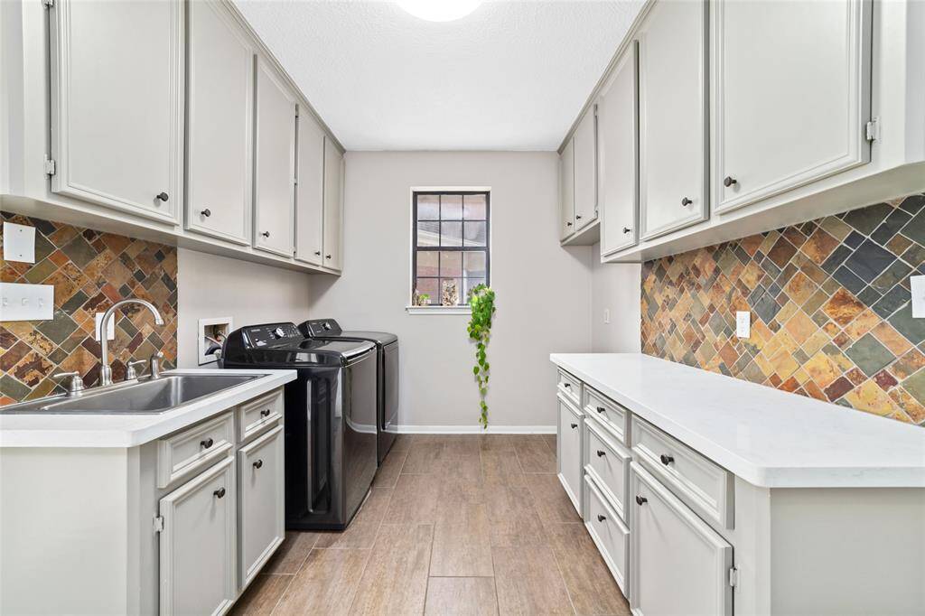Huge laundry room/mud room is conveniently located just off the kitchen with an additional entrance from the backyard/garage area. Features a stainless steel sink, backpack station with bench and open storage, and tons of counter and cabinet space. Washer and propane gas dryer included.