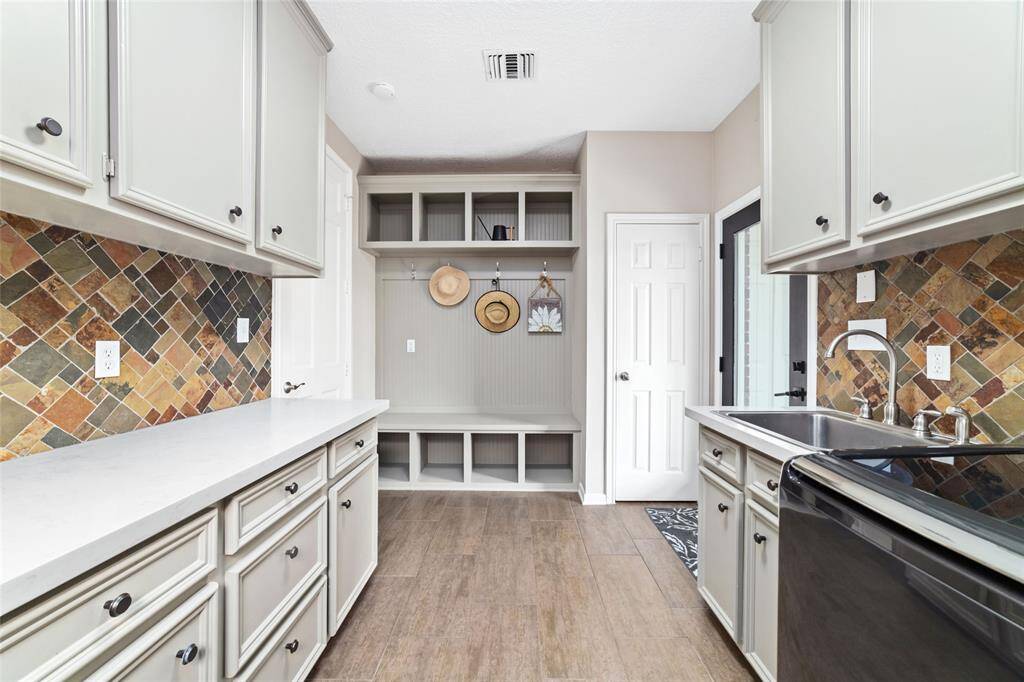 Another view of the spacious laundry room offering an abundance of cabinetry, counter space and storage.