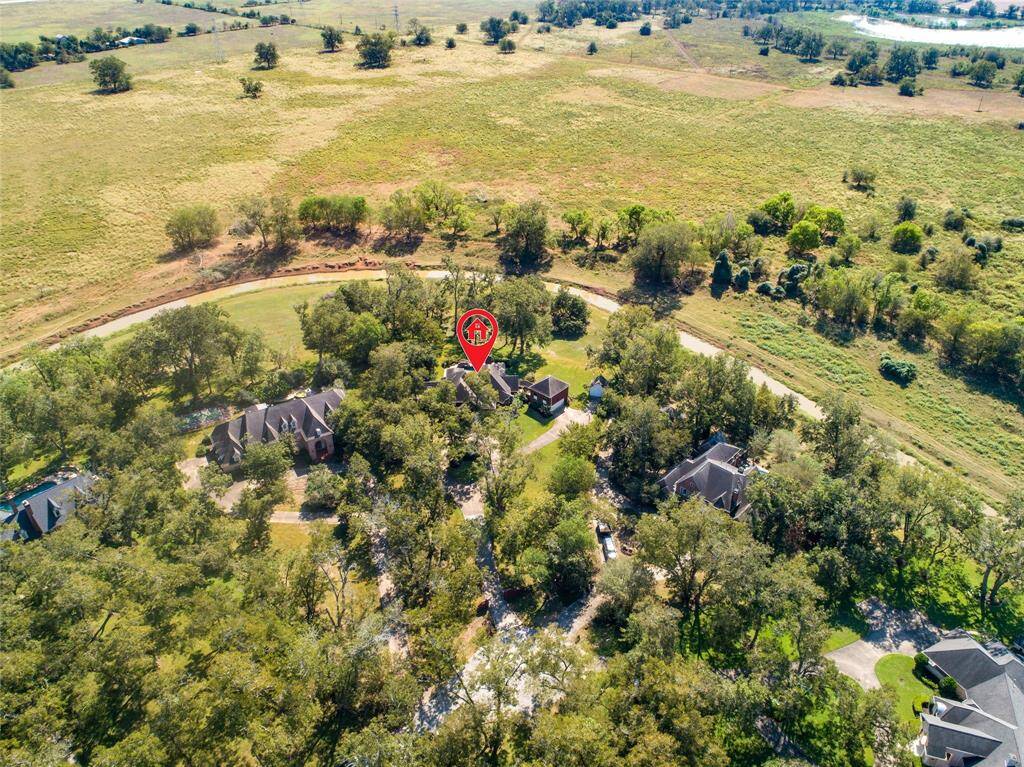 Aerial view showcasing the spacious cul-de-sac property surrounded by mature trees and offering privacy and a serene backdrop of Jones Creek. Per the Sellers, this home has NEVER flooded.