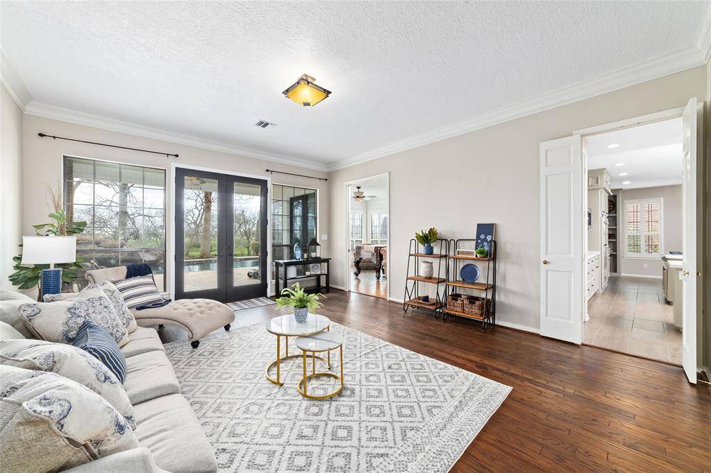 Exquisite living room features recently refinished wood flooring, large windows and double french doors leading to the backyard oasis.