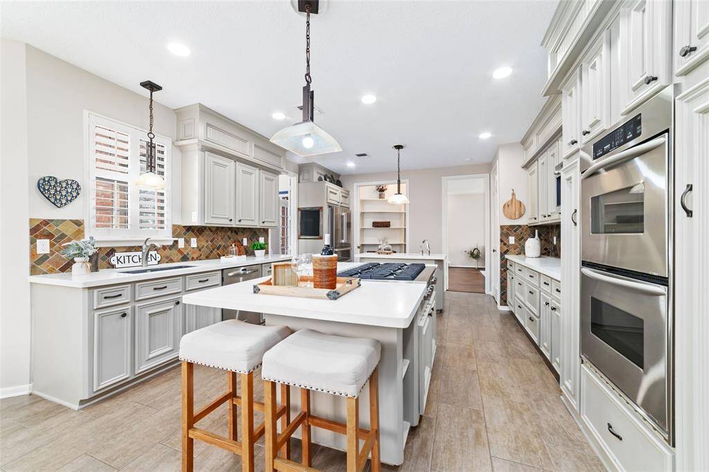 This exquisite kitchen continues to impress with its array of high-end features. Sleek stainless steel appliances elevate both form and function, while a double convection oven promises culinary precision. For the ultimate in storage and organization, a spacious walk-in pantry stands ready to accommodate all your gourmet essentials.