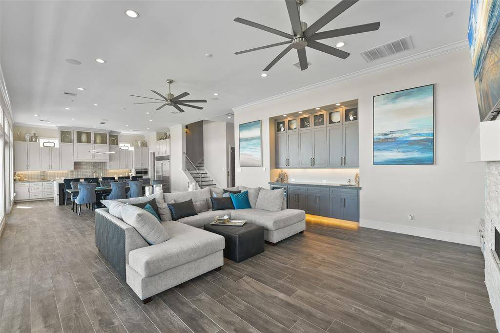 Entertain with ease with a custom-built wet bar, featuring elegant cabinetry and recessed lighting. Surround-sound wiring for the family room & built-in speakers for the kitchen island area ensures that this space is designed for both style and functionality- perfect for hosting in luxury.