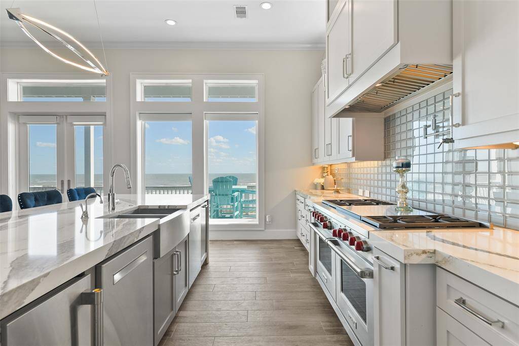 Enjoy the best of coastal living with stunning beachfront views right from your farmhouse-style apron sink- which is perfectly positioned to let you take in the ocean while enjoying custom cabinetry, quartz countertops, and elegant lighting.