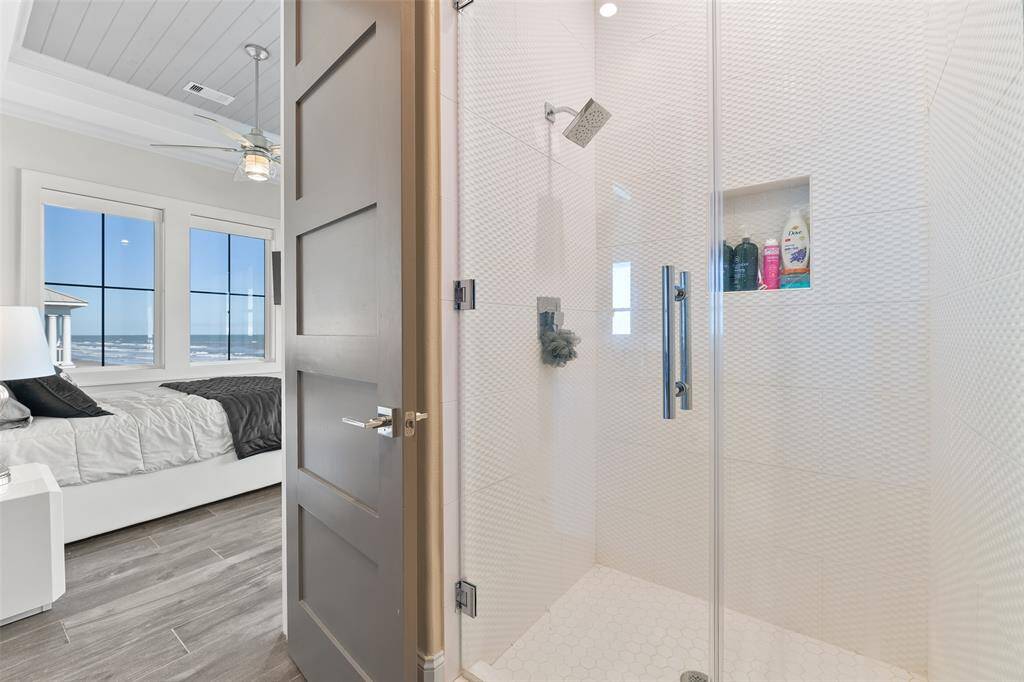 The ensuite bathroom boasts a full-sized shower with exquisite custom tile work, creating a luxurious and inviting space for relaxation.
