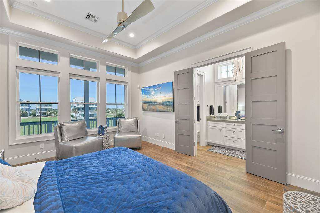 With custom designer flooring, panoramic water views, and a charming seating area, this bedroom is the ultimate sanctuary.