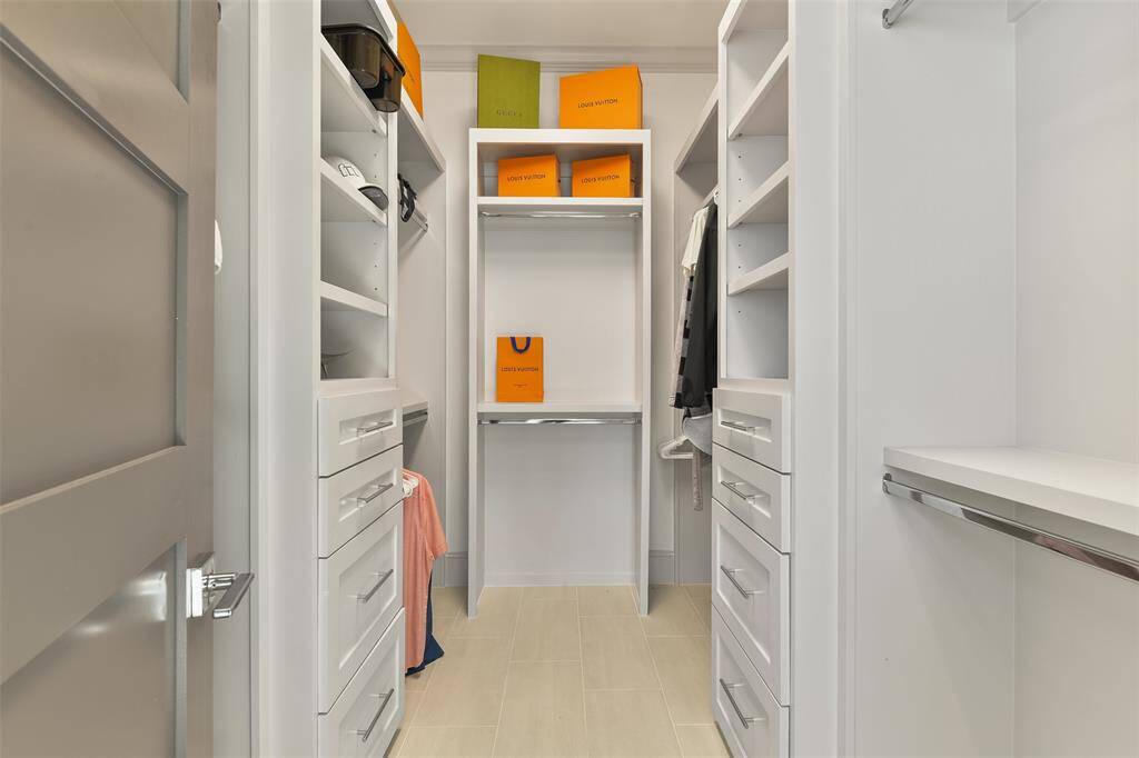 The primary walk-in closet is a dream come true, featuring 8 hanging spaces and custom-built shelving to accommodate all your clothing, accessories, and storage needs. A perfect blend of style and organization for luxury living.