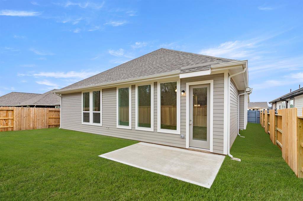 The backyard offers a peaceful outdoor space with a concrete slab that’s perfect for grill